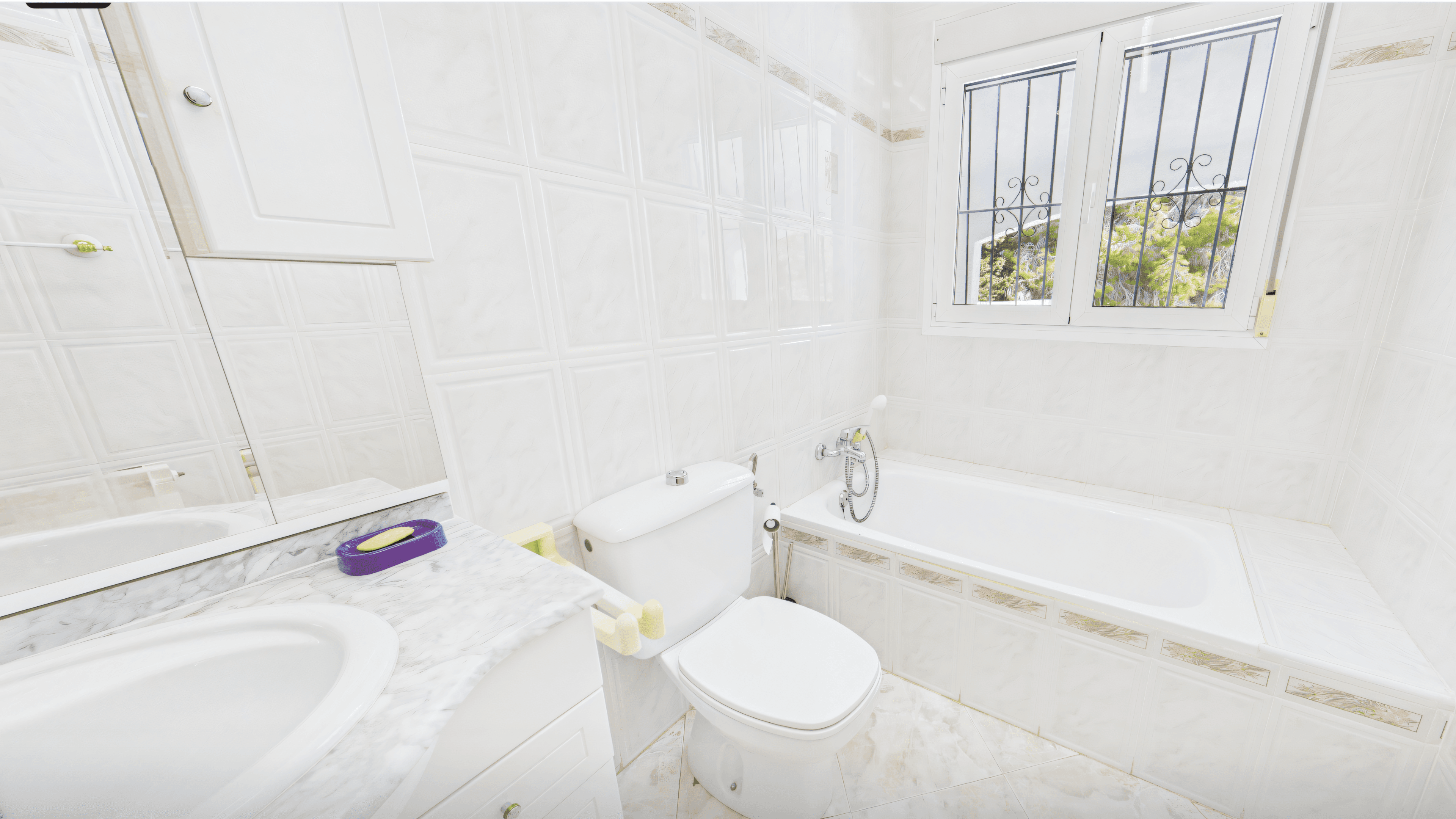 Before: old tiled bathroom with grille window and white bathtub