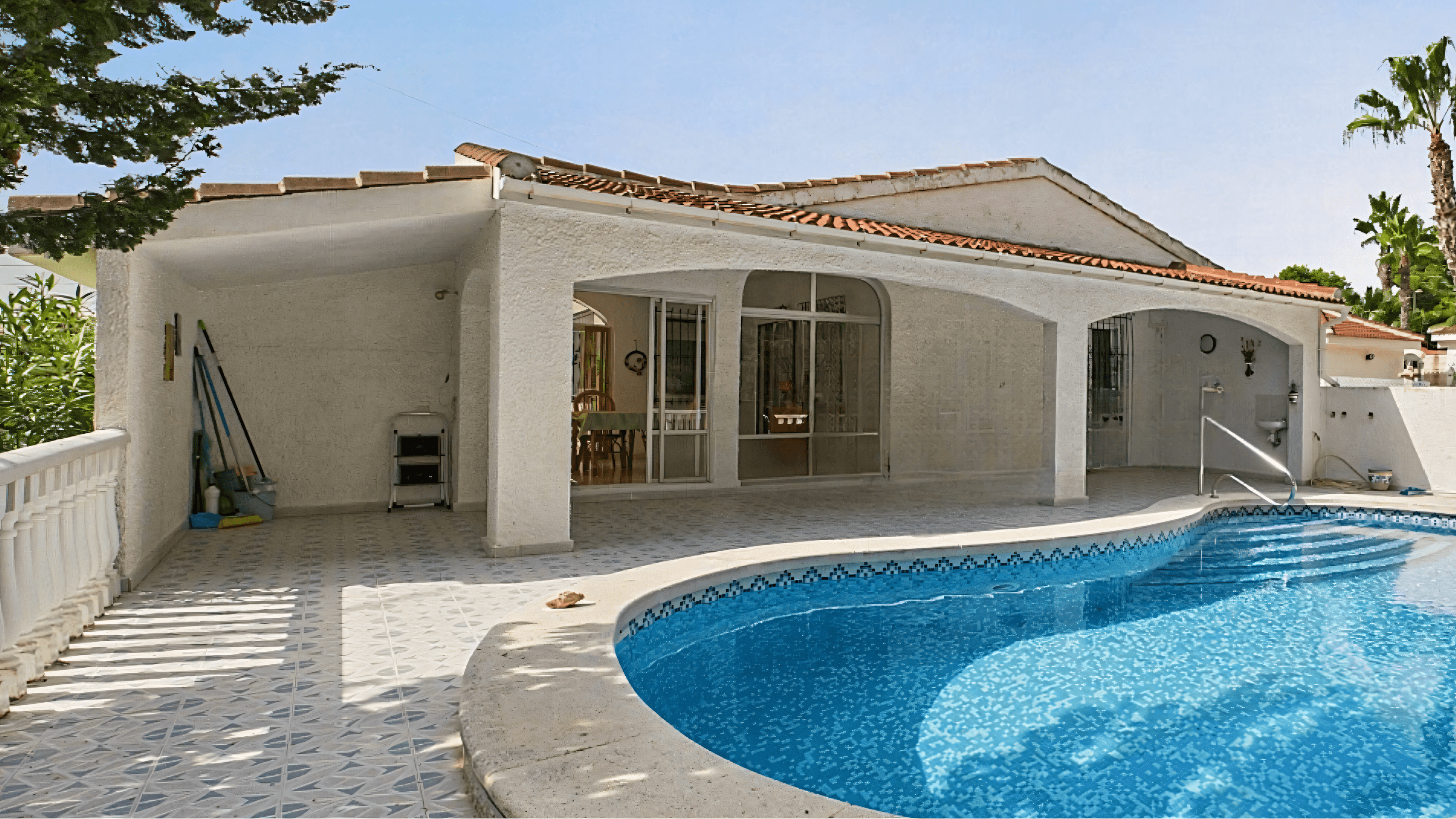 Before: white villa with pool and covered terrace