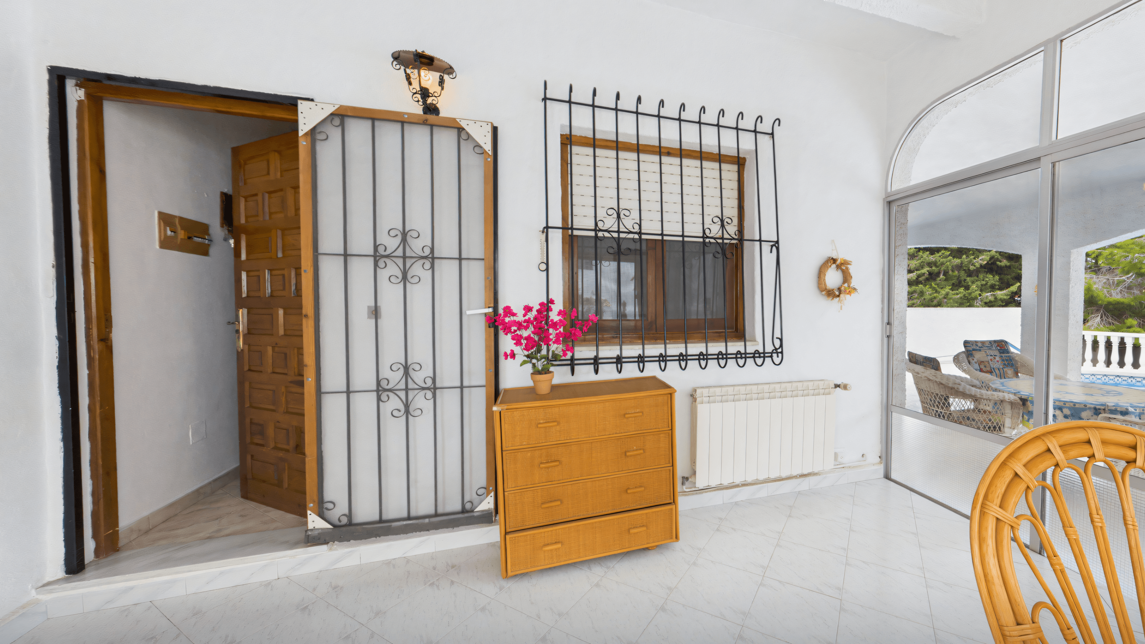 Before: old conservatory with wrought-iron grille and oak chest