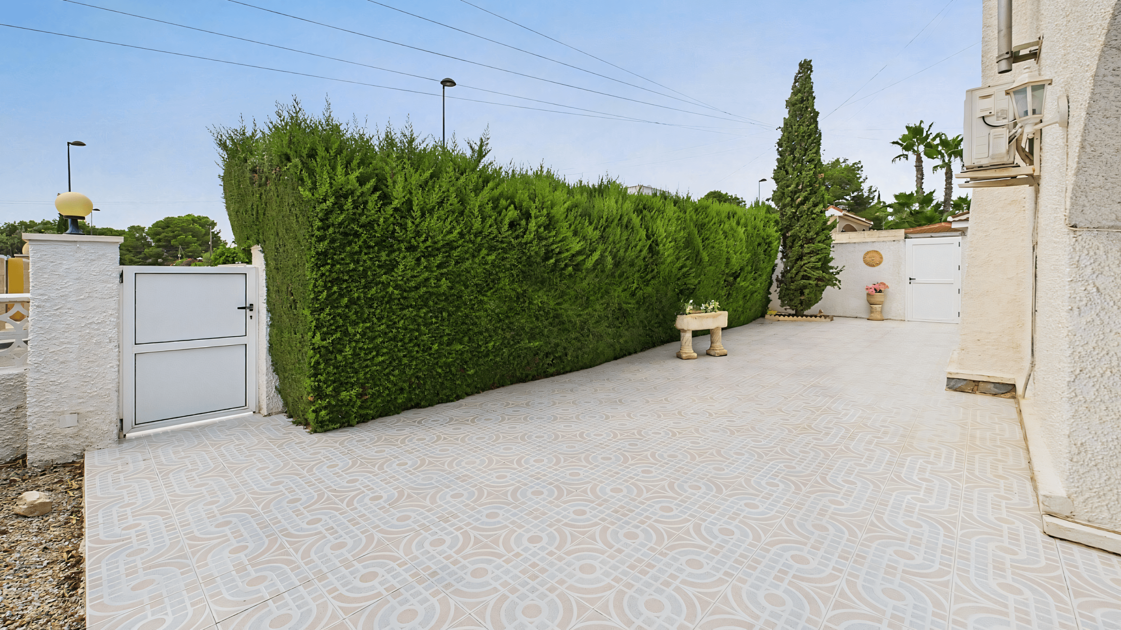 Before: old terrace with hedge and patterned tile floor