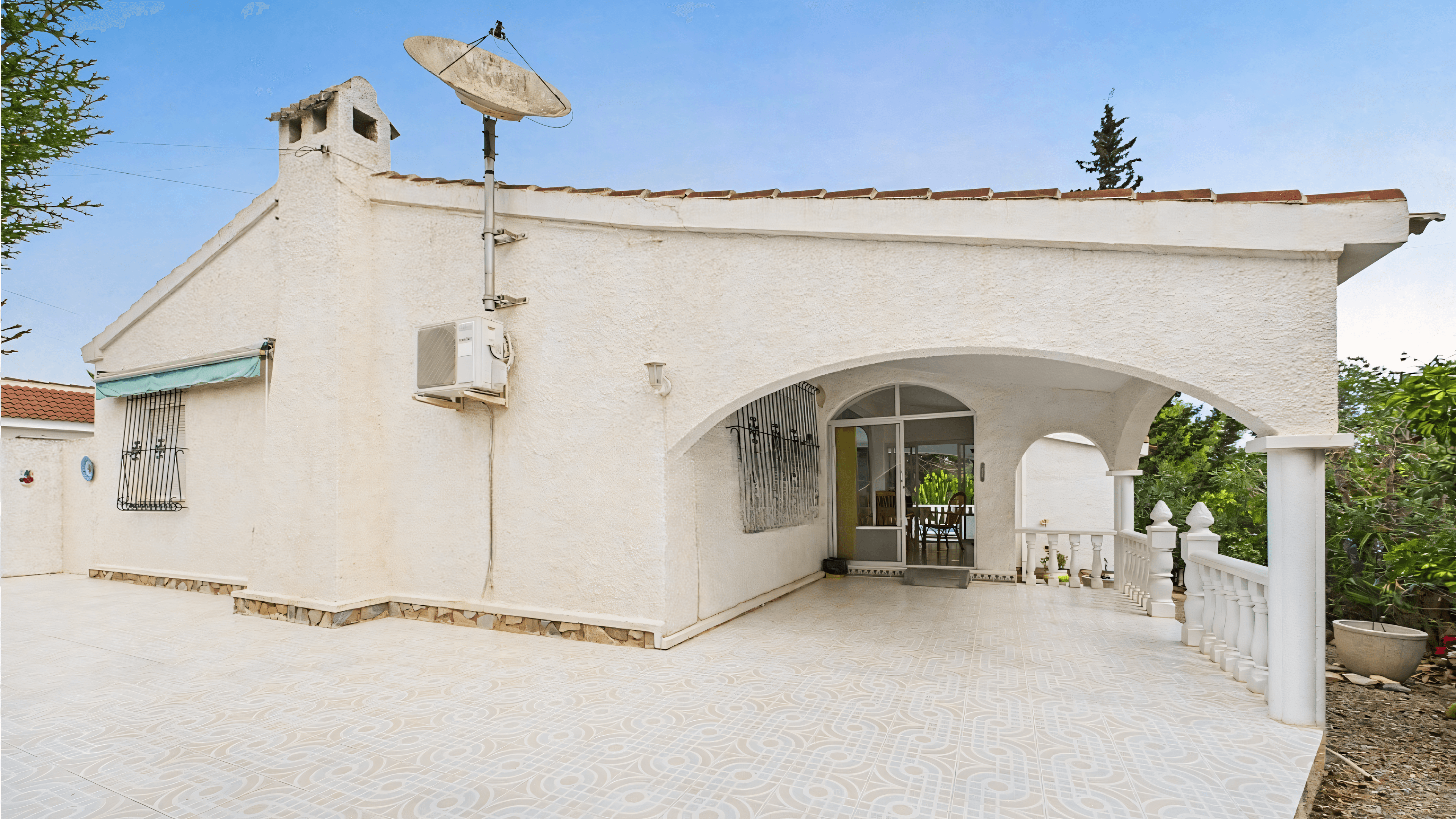 Before: old white villa with satellite dish and balustrade